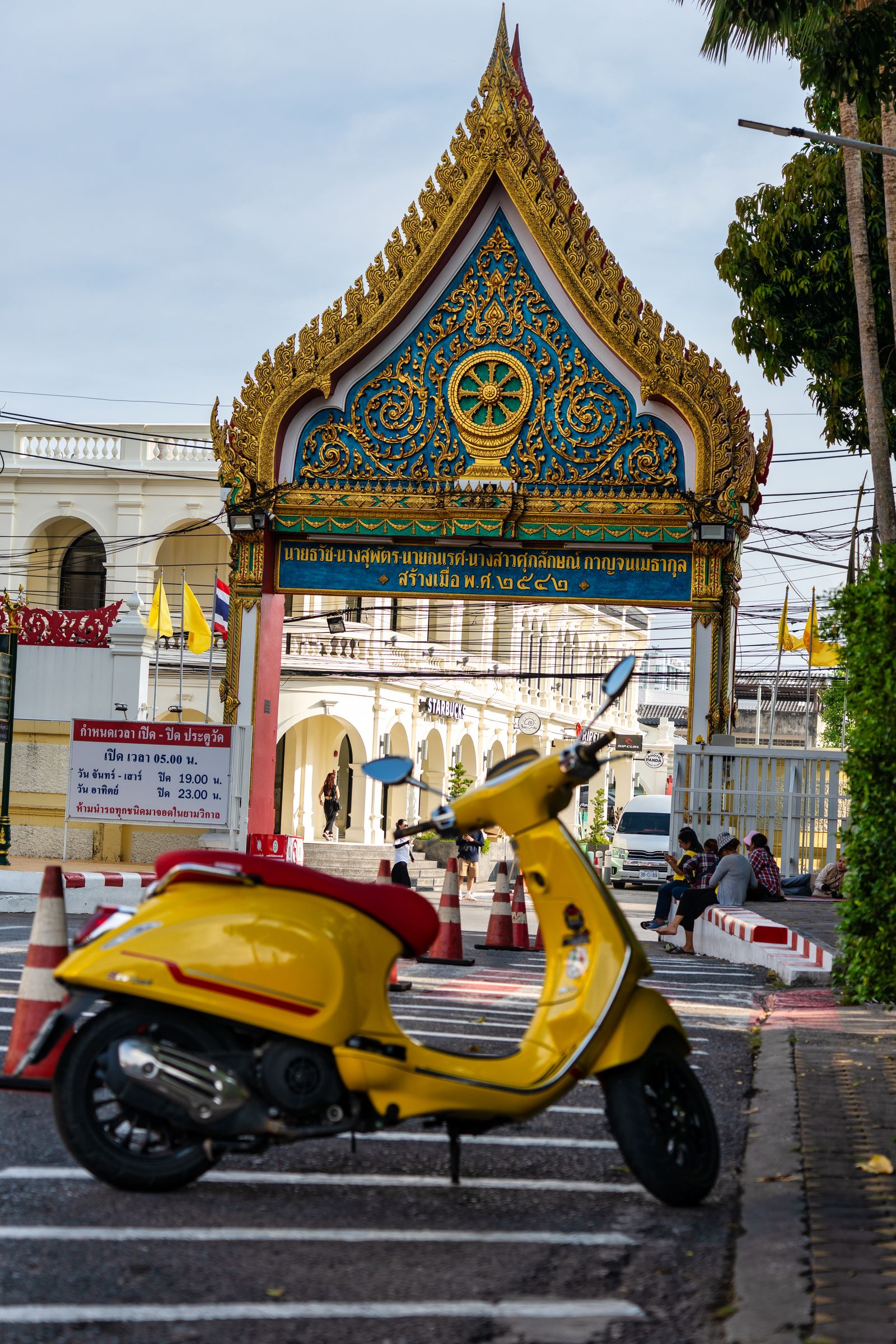 Scooter jaune devant une porte de temple